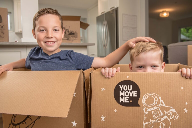 two boys sitting in moving boxes
