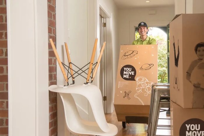a smiling You Move Me mover bringing in boxes